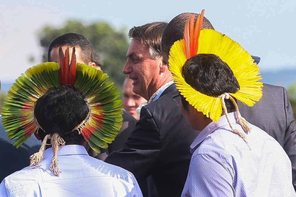 O presidente Jair Bolsonaro se encontra com indígenas durante a cerimônia de hasteamento da bandeira nacional. Imagem: Agência Brasil