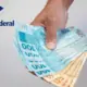 Pessoa segurando dinheiro e logo da Receita Federal