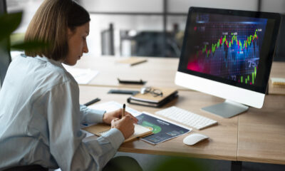 mulher anotando estatísticas de finanças