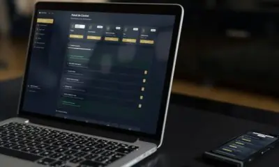 Notebook e smartphones sobre uma mesa; ambos estão conectados no mesmo website, mostrando um dashboard de informações.